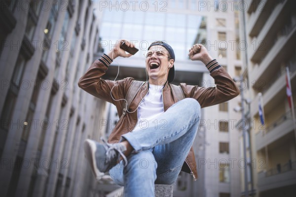 Man Sitting Listening Music Earphones Concept. Cheerful young guy listening the music