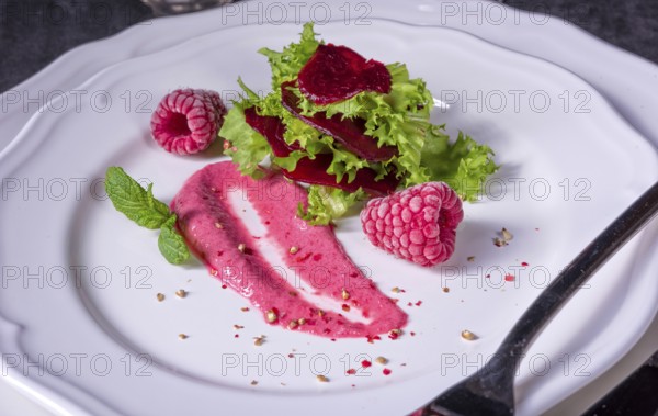 Carpaccio of baked red pray with green salad and raspberry