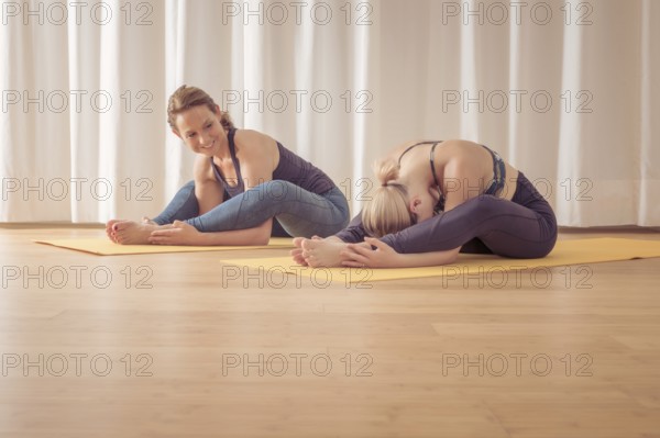 An image of two women doing yoga at home