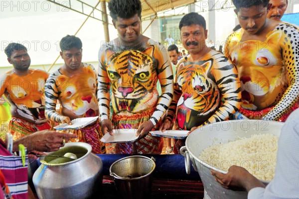 Men eating lunch before Pulikali Tiger Dance, Onam festival, Thrissur, Kerala, India, Asia