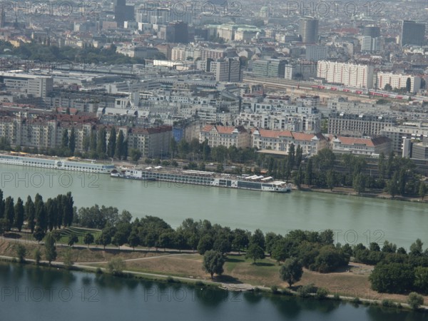 City view with buildings along a river and green trees, Vienna, Austria, Europe