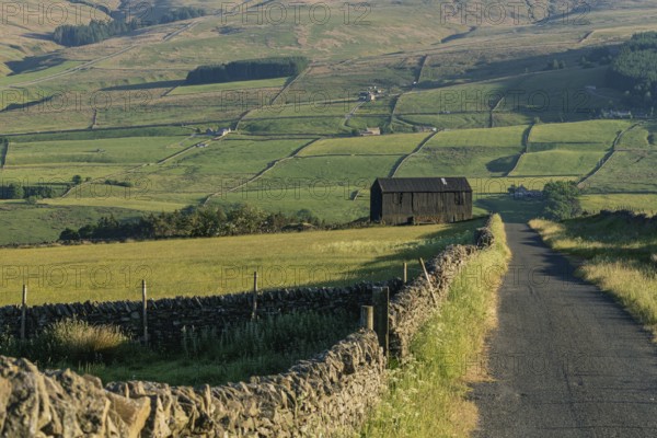 A black barn on the side of a rural road in the Peak District between Rookhope and Ireshopeburn, County Durham, England, UK