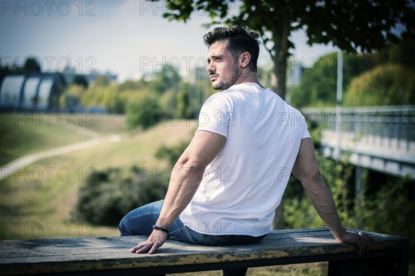 Attractive muscular man in city park in a nice summer day