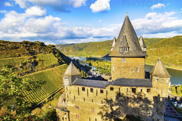 Round towers with conical peaked roofs. Sunset. Rhine Castles: Journey into the German Middle Ages. The hills are home to the well groomed vineyards