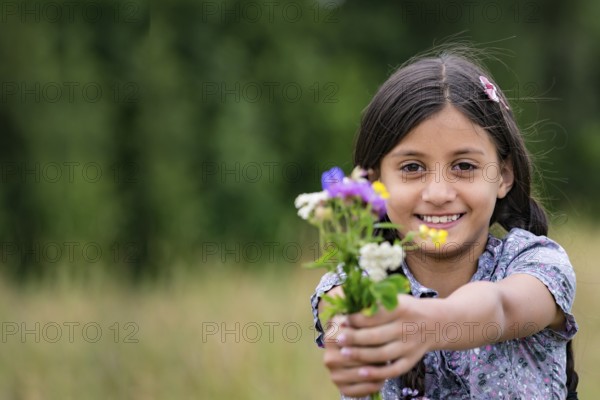 Pretty girl with self-picked bouquet of flowers