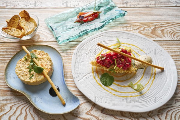 Food starters potato salad Steak tartare and Anchovies with tomato Tapas