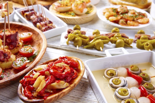 Tapas mix and pinchos food from Spain recipes also pintxos on a white wood board