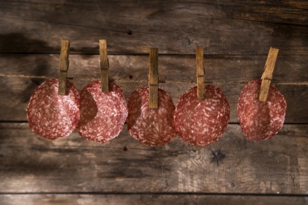 Presentation of slices of salami hanging by a thread
