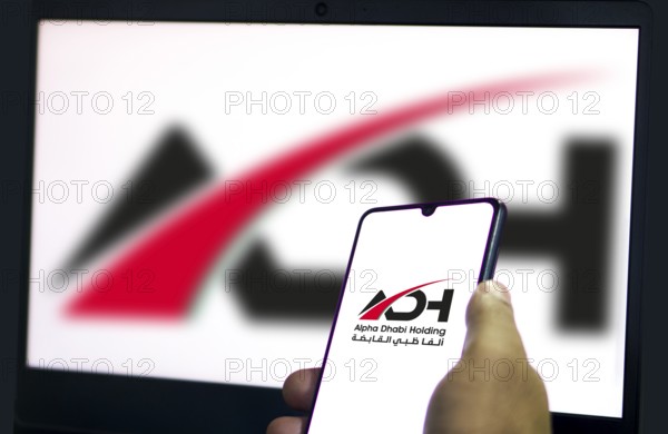 Alpha Dhabi Holding (ADH) logo on smartphone.