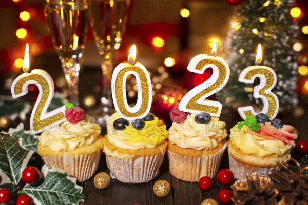 Food tray with cupcakes new year candles and wineglasses