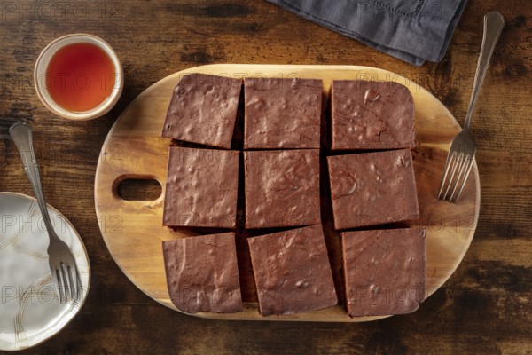 Chocolate brownie with tea, simple coffee cake, overhead flat lay view on a dark rustic wooden background, Food photography, Food photography