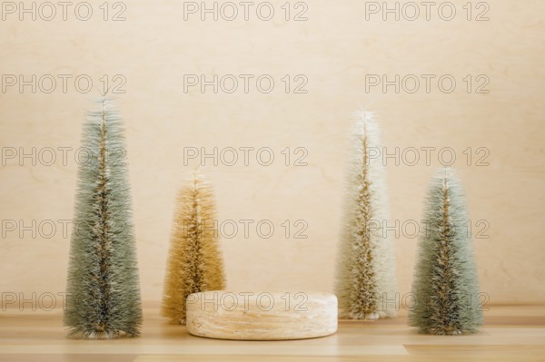 Wooden podium pedestal product mockup display with miniature Christmas trees in beige and green, 3d illustration