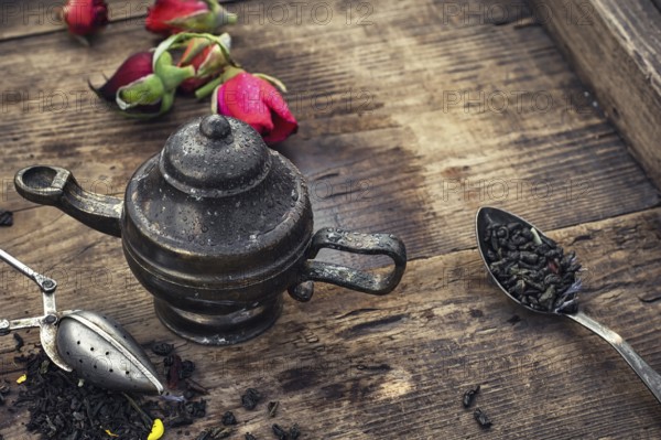 Stylish spoons with variety of tea on vintage wooden board
