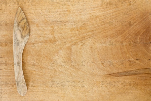 Wooden knife on a wooden background. Studio shot. Kitchen utensil