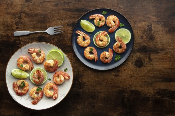 Shrimps, overhead flat lay shot on a rustic wooden background, with copy space. Cooked shrimp with lime, Mediterranean cuisine, Food photography