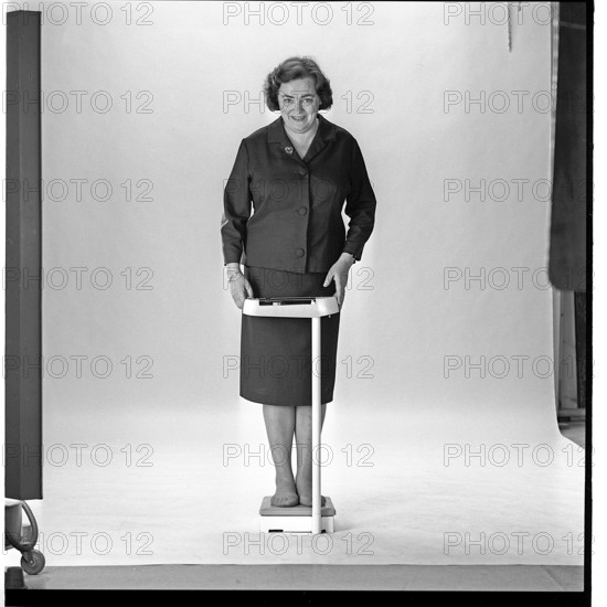 Woman in the 1960s. She is standing and weighs herself on a scale. Sweden november 1965