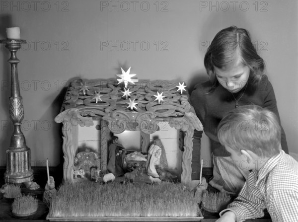 Christmas in the 1950s. Two children with a nativity scene, infant Jesus resing in a manger, Mary and Joseph. Sweden 1950 ref I2144