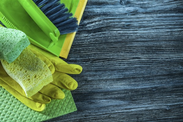 Dustpan brush sponges safety gloves dishcloth on wooden board