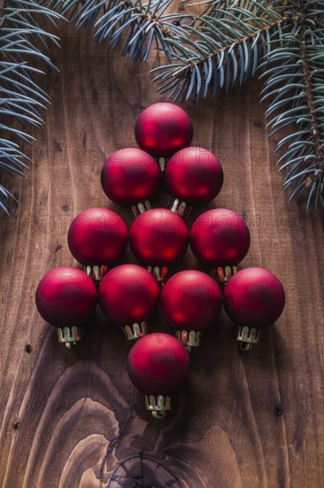 Red christmas baubles in the form of fir tree and branches firtree vintage wood board