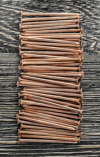 Stack of copper nails on wooden board