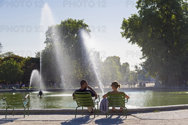 Paris, France, September 3, 2018: A man and a woman are resting by the pond in the Tuileries garden. Paris, France. A sunny day in early September, Europe