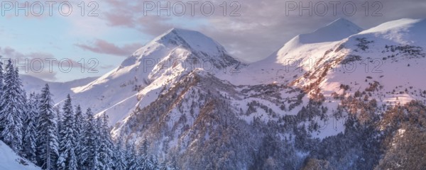Pirin, Bulgaria winter travel vacation nature panoramic background with snow covered mountain peaks and sunset sky with clouds close-up