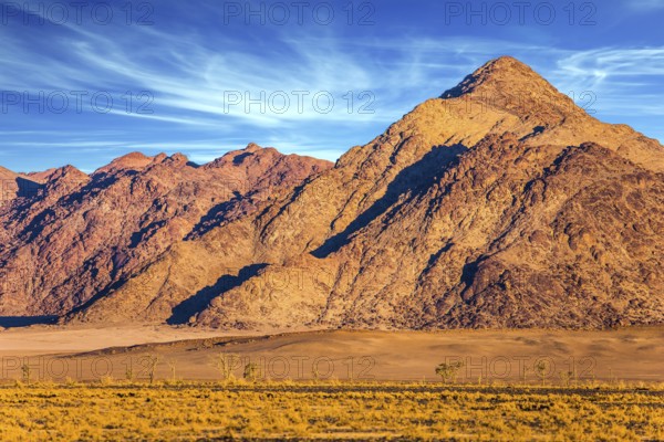 Purple and yellow mountains of the Namib desert. Sunset, Namibia. The concept of extreme and exotic tourism