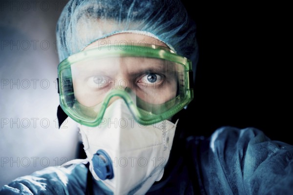 Close-up of a medical professional in protective gear with an intense gaze