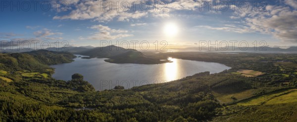 An aerial panorama of Caragh Lake in County Kerry with the sun setting over the lake