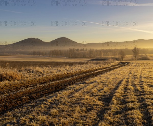 Sunrise in Rudawy Janowickie. View of Rudawy Janowickie. Frozen field at sunrise