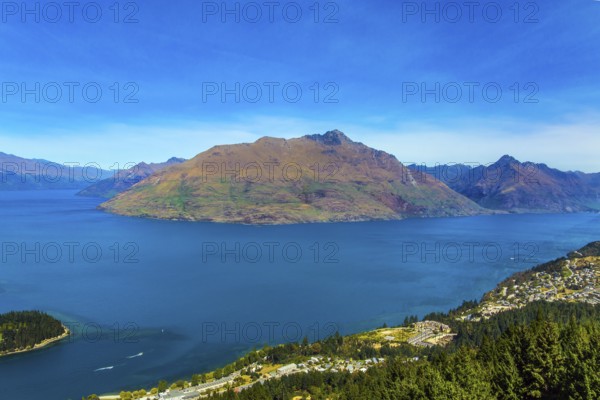 The concept of active, ecological and photo tourism. Bird's eye view. The city Queenstown, shores of Lake Wakatipu. Travel to New Zealand, South Island. Huge azure lake among the mountains