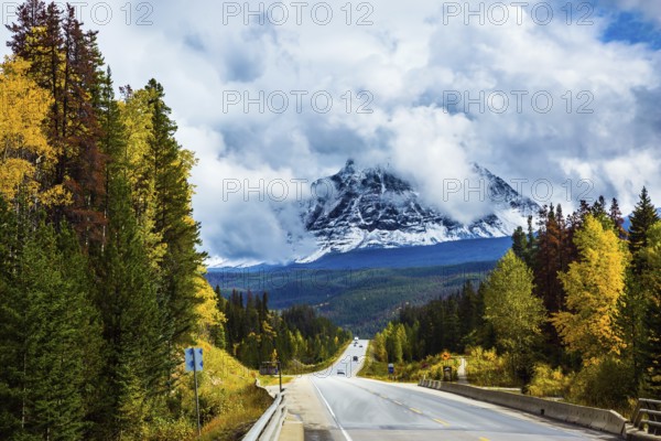The astonishing Highway 93 Icefields Parkway passes among the snow-capped mountains. The grandiose nature of the Rockies of Canada. The concept of active car tourism