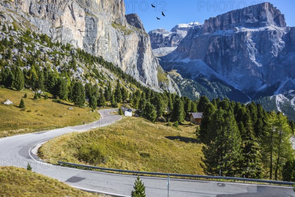 Indian summer in the Tyrol. The concept of extreme and ecological tourism. Impressive ridge of dolomite rocks. Picturesque road through the Sella Pass, Dolomites