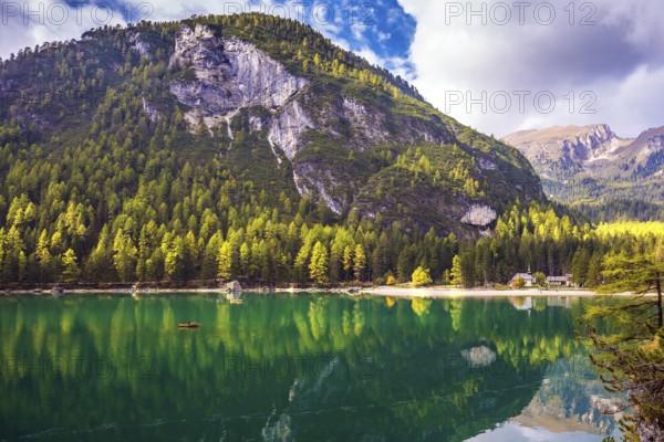 Magnificent lake Lago di Braies. Emerald expanse of water reflects the surrounding forest and mountains. The concept of walking and eco-tourism. South Tyrol, Italy, Europe
