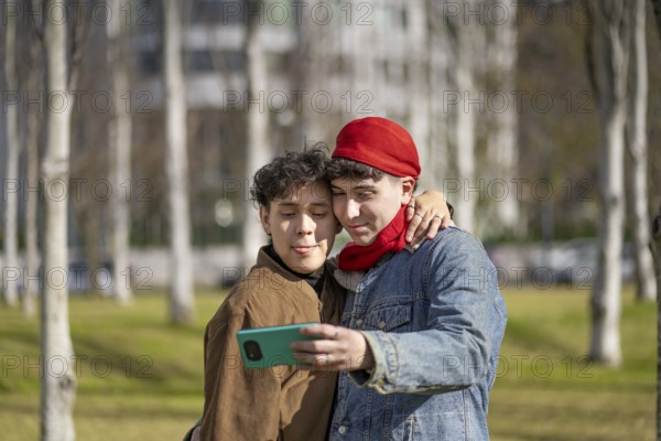 Young gay couple making funny faces taking selfies