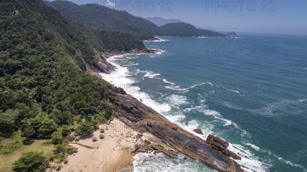 Aerial view to wonderful Green Coast shoreline with rock slabs, beach and mountains covered with Atlantic Forest, Picinguaba, Brazil, South America