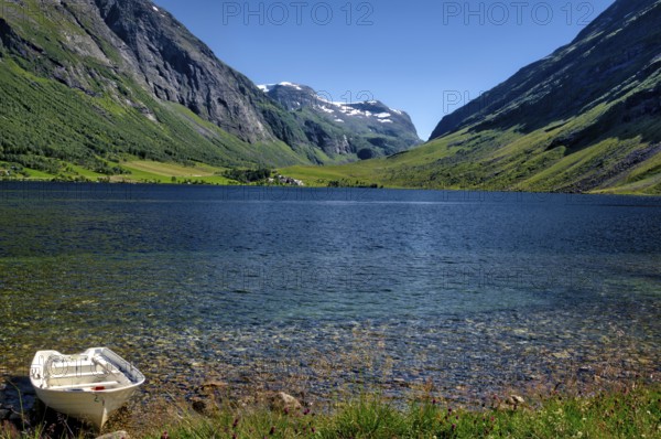 The landscape with a mountain lake near the Geirangerfjord in summertime in Norway is beautiful and a very famous travel point for Scandinavian travellers. The landscape with a mountain lake near the Geirangerfjord in summertime in Norway is beautiful and a very famous travel point