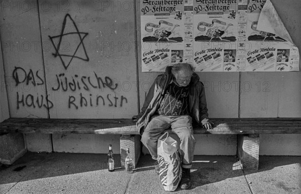 Germany, Berlin, 18 October 1991, a homeless man in a bus shelter in Marzahn, The Jewish house Rhinstraße, Europe