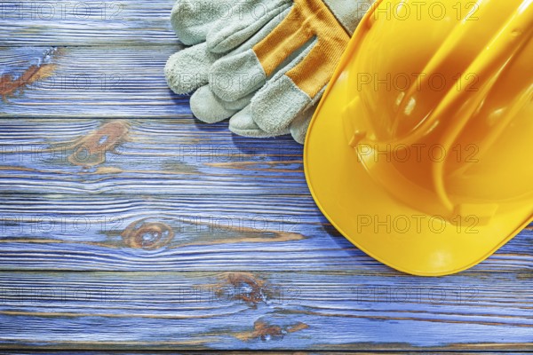 Safety gloves hard hat on vintage wooden board