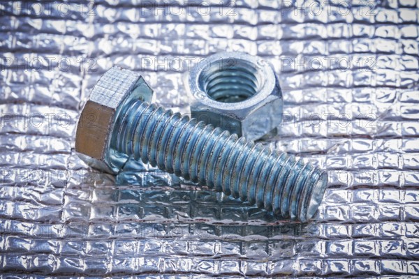 Stainless bolt and screw nut on metal background construction concept