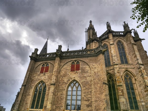 Gothic brick church with high windows and a dramatic, cloudy sky, Xanten, North Rhine-Westphalia, Germany, Europe