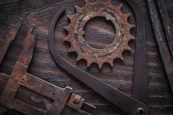 Set of rusty measuring calipers with cog- wheel on vintage dark wooden surface construction concept