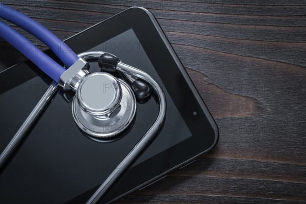 Close up of stethoscope and pad on vintage wooden background medicine concept