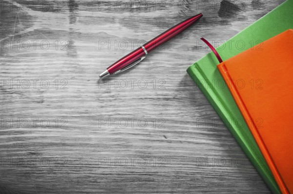 Note-books pen on wooden board education concept