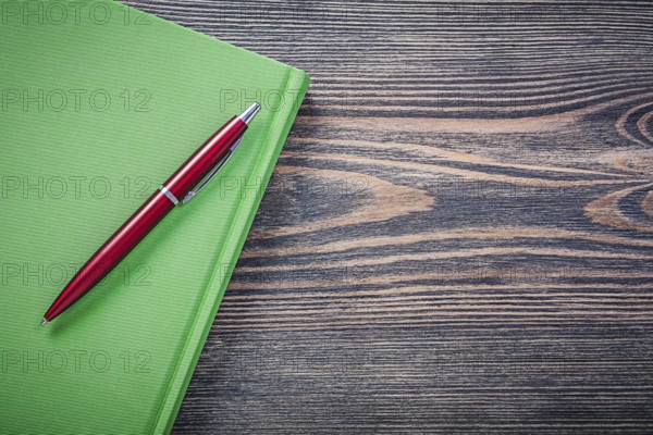 Notepad brio pen on wooden board copy space