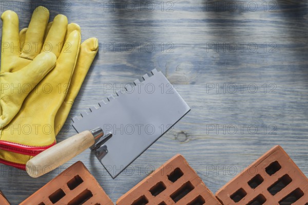 Red construction bricks leather safety gloves putty spattle building concept