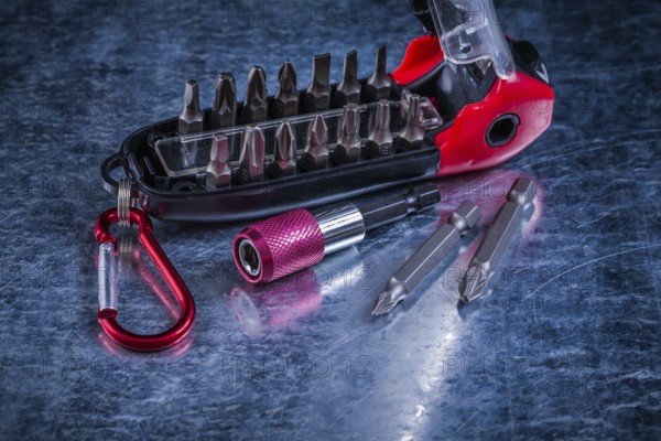 Screwdriver with muunction bit set on scratched metallic background