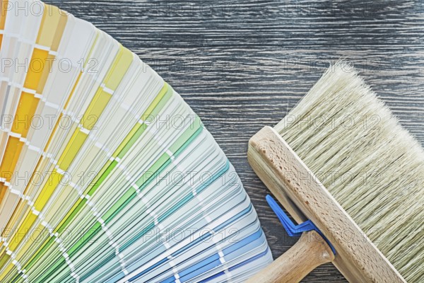 Horizontal view of color palette fan paintbrush on wooden board