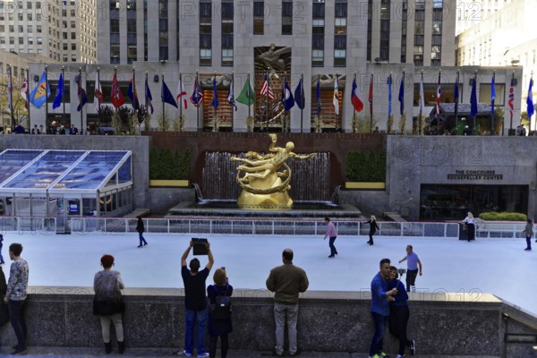 Rockefeller Center, Manhattan, New York, USA, North America, Prometheus bronze sculpture at Rockefeller Center building in New York City USA, People skating at Rockefeller Center with sculpture in the background, New York City, North America