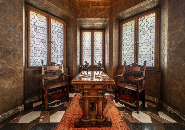 Krakow, Poland, March 23, 2024, Interior of a bowed window with stained glass, luxury chairs and a carved wooden table, Europe